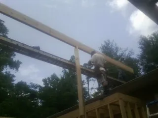 Carpenter setting a ridge beam over a new addition frame — Ice Dam Removal by Roofing Brothers in Dowagiac