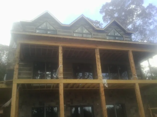 Dormers and porch framing on a large log home under construction — Roof Coating work by our crew in Dowagiac