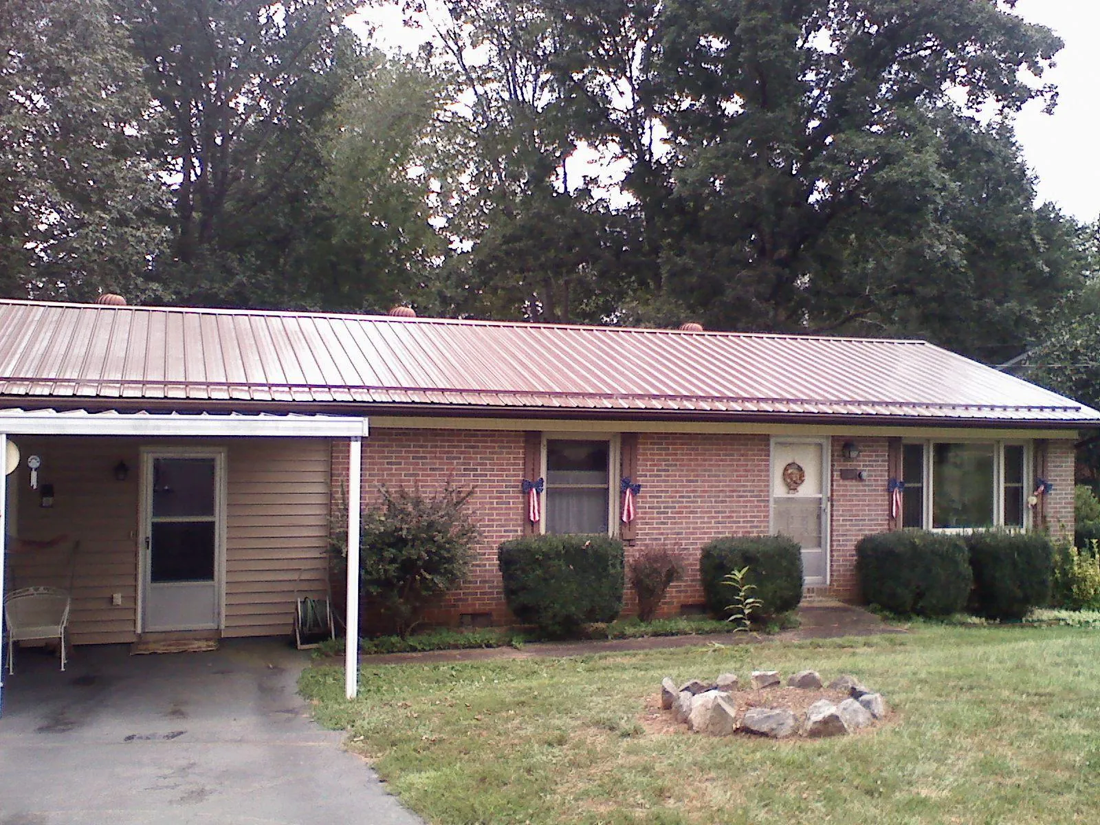 Bronze metal roof and carport on a brick ranch home — Roof Repair work by our crew in Dowagiac