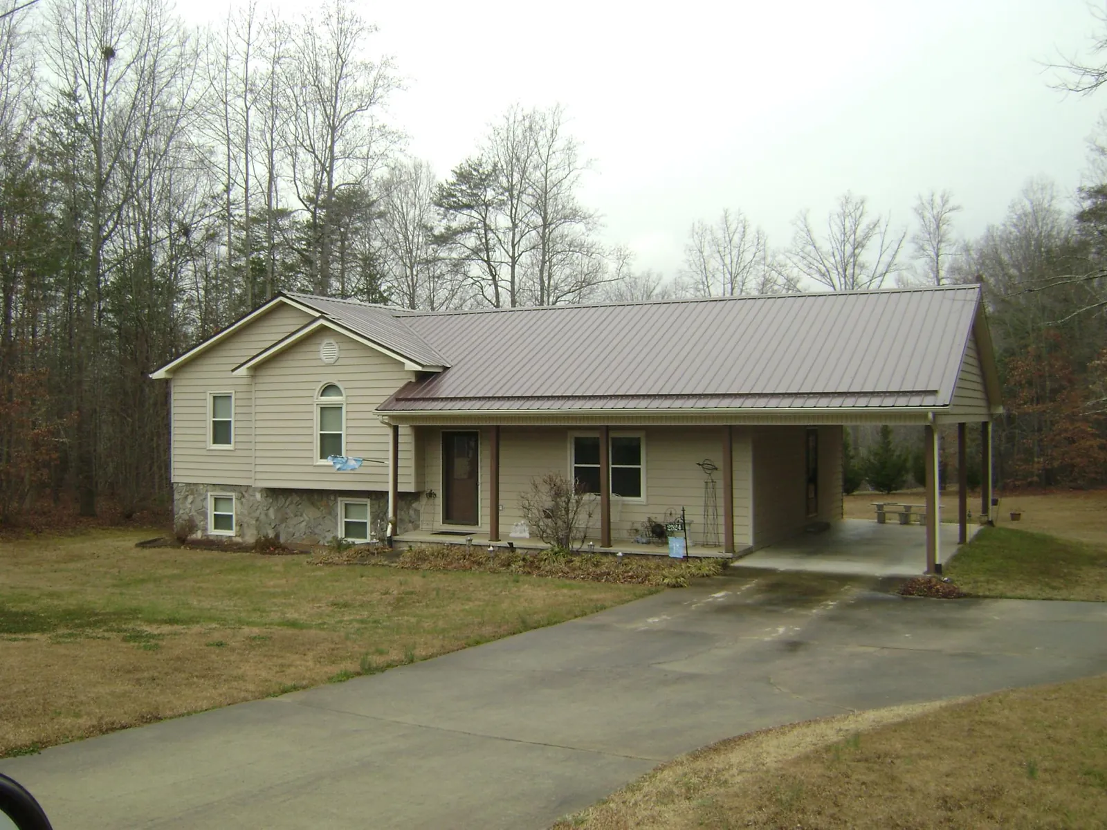 Brown metal roof on a tan split level home with an attached carport in Dowagiac